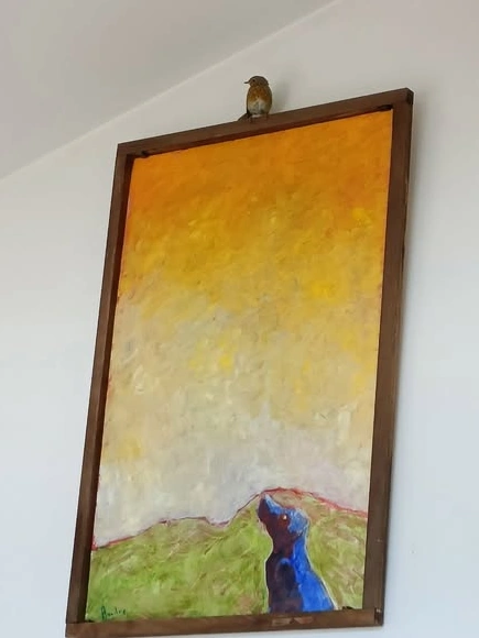 Toile de Jean-François Andre : la chienne Tsanga lève la tête vers un ciel orangé ; un oiseau vivant est posé sur le haut du cadre